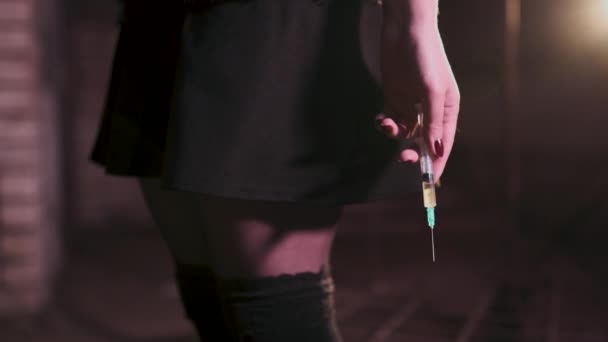 Σύριγγα κοντά στα χέρια ενός εθισμού στα ναρκωτικά κοκκινομάλλα Καυκάσιος λευκή νεαρή γυναίκα φορώντας μαύρο πουλόβερ, φούστα και σοκολατόπουλο-άγχος, κατάθλιψη και αίσθημα κινδύνου — Αρχείο Βίντεο