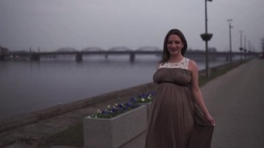 Genç hamile kadın seyahat yeri Letonya 'da Riga şehri ve Daugava nehrinin manzarasıyla mutlu.
