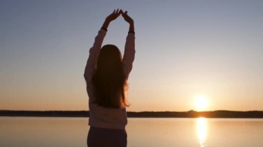 Genç bir kadın, baharda, bir nehir sahilinde gün batımını sever. Beyaz pantolon, kısa ceket ve beyaz ceket giyer. Beyaz, mutlu bir gezgin.