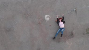 Bir ceket ile mavi kot pantolon ve pembe t-shirt giyen bayrak gösteren aktris gibi hareket Chained kapana kısılmış kadın kavramı Anten - Kafkas beyaz kızıl kız - Yukarıdan üstten görünümü