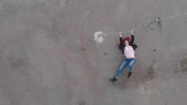 Aerial of Chained donna intrappolata concetto che agisce come attrice mostrando bandiera indossando jeans blu e rosa t-shirt con una giacca - caucasica rossa bianca ragazza - Vista dall'alto — Video Stock