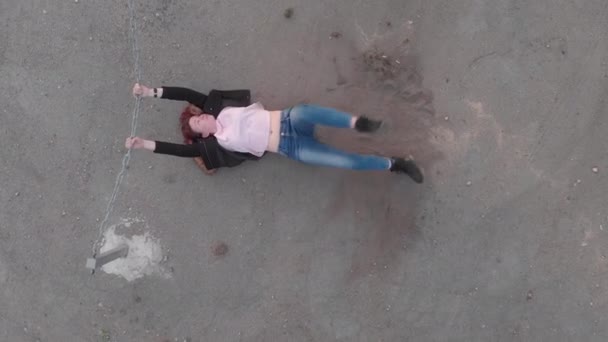 Aerial of Chained trapped woman concept acting like actress showing flag wearing blue jeans and pink t-shirt with a jacket - Caucasian white redhead girl - Top view from above — Stock Video