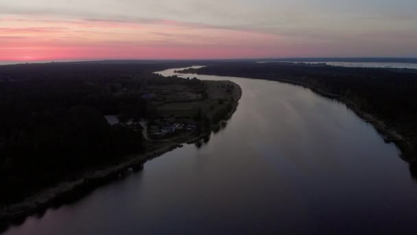 空中トップビューは、真紅の紫とピンクの空と日の出の間にユルマラ、ラトビアの春2019のリレルペ川の上を飛ぶ - 太陽はかろうじて示しています — ストック動画