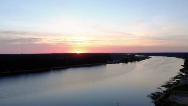 진홍색 보라색과 분홍색 하늘이 있는 일출 동안 2019 년 라트비아 봄 유르말라의 리루페 강 위로 공중 탑 뷰 비행 - 태양이 간신히 보여 — 비디오