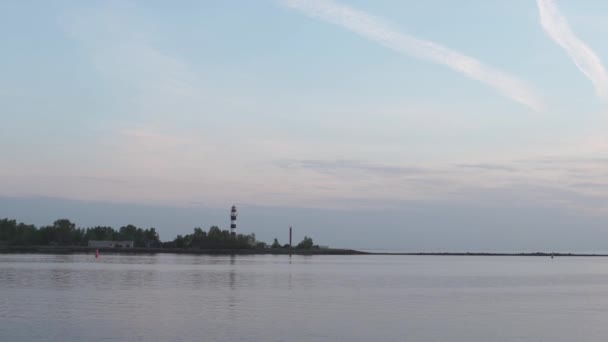 マンガルサラ、ラトビアのゴールデンアワーの間に縞模様の灯台の夕日の景色 - ボルデラジャ部分 - クリーミーな風景 — ストック動画