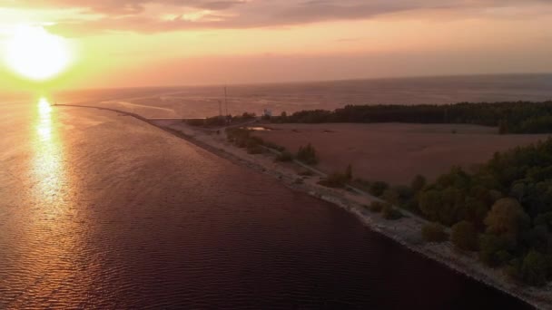 Faro aéreo épica filmación cinematográfica con muy pocas nubes y el anochecer caliente - Vista del dron desde arriba del río entra en el golfo del Mar Báltico - Suave movimiento profesional nd filtro — Vídeo de stock