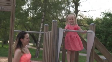 Mutlu anne onun küçük bebek kız kızı ile oynarken ve eğlenmek - Genç kafkas beyaz anne yaz parlak canlı renk elbise giyiyor - Happinness aile konsepti