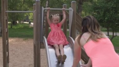 Mutlu anne onun küçük bebek kız kızı ile oynarken ve eğlenmek - Genç kafkas beyaz anne yaz parlak canlı renk elbise giyiyor - Happinness aile konsepti