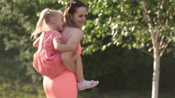 Feliz madre jugando con su hija pequeña niña y divertirse - Joven madre blanca caucásica usando vestido de color vivo brillante verano - Concepto de familia felicidad — Vídeos de Stock