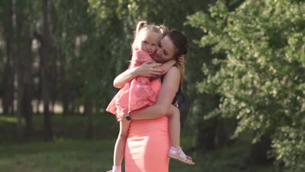 Felice madre giocando con la sua bambina figlia e divertirsi - Giovane mamma bianca caucasica che indossa l'estate brillante abito di colore vivido - Happinness concetto di famiglia — Video Stock