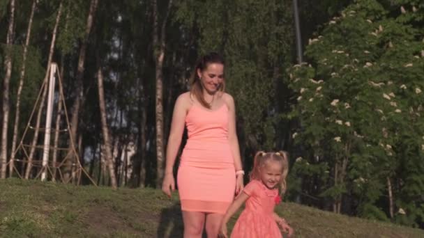 Mère heureuse jouant avec sa petite fille et s'amusant - Jeune mère blanche caucasienne portant une robe de couleur vive en été - concept de famille Happinness 