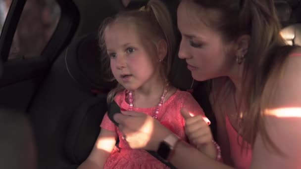 Cinturón de seguridad abrochar asiento de coche del niño con la madre y la hijaJoven mamá blanca caucásica usando vestido de color vivo brillante del verano — Vídeo de stock