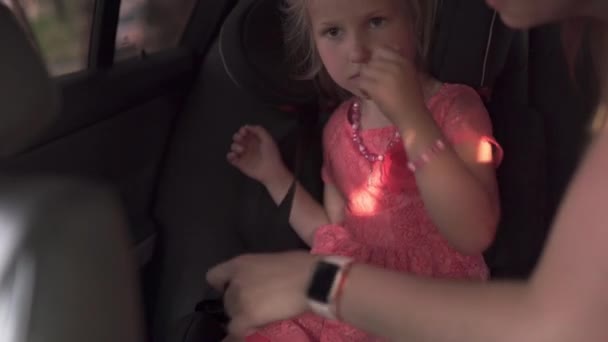 Ζώνη ασφαλείας Στερεώστε το παιδικό κάθισμα του αυτοκινήτου με τη μητέρα και την κόρη νεαρό καυκάσιο λευκό μαμά φορώντας το καλοκαίρι φωτεινό ζωντανό χρώμα φόρεμα — Αρχείο Βίντεο