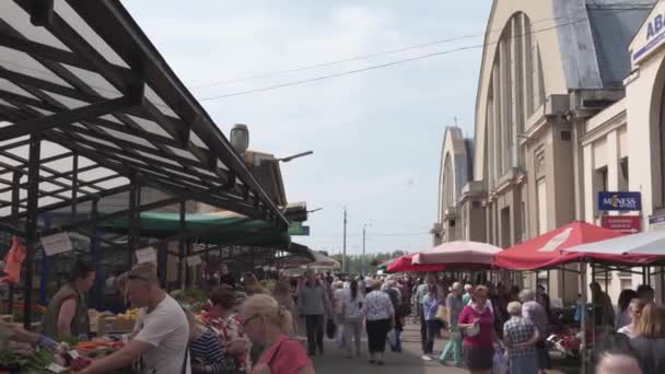 RIGA, Letonia - 21 de mayo de 2019: Mercado Central centralais tirgus lleno de turistas y lugareños que buscan comprar alimentos y verduras - Vista exterior de los antiguos hangares alemanes de Zepelin — Vídeos de Stock