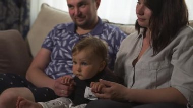 Aile değerleri: Anne ve baba bebek çocuk çocuk kapalı ile oynarken - Ebeveynler mavi ve gri ev giyim ve oğulları siyah beyaz giyen - Mutlu gülümseyen insanlar