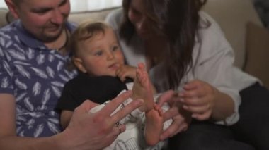 Aile değerleri: Anne ve baba bebek çocuk çocuk kapalı ile oynarken - Ebeveynler mavi ve gri ev giyim ve oğulları siyah beyaz giyen - Mutlu gülümseyen insanlar