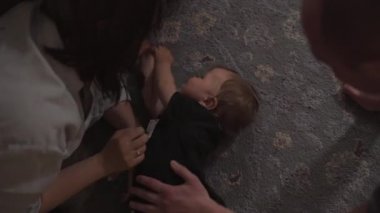 Aile değerleri - gıdıklamak: Anne ve baba bebek çocuk çocuk kapalı ile oynarken - Ebeveynler mavi ve gri ev giyim ve oğulları siyah ve beyaz giyen - Mutlu gülümseyen insanlar