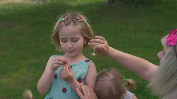 Joven madre hippie rubia teniendo tiempo de calidad con sus niñas bailando en un parque - Hijas usan vestidos similares con estampado de fresa — Vídeo de stock