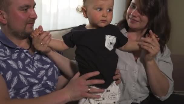 Aile değerleri: Anne ve baba bebek çocuk çocuk kapalı ile oynarken - Ebeveynler mavi ve gri ev giyim ve oğulları siyah beyaz giyen - Mutlu gülümseyen insanlar — Stok video