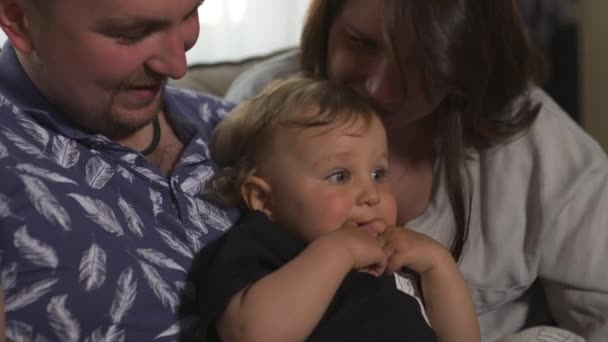 Familie waarden: moeder en vader spelen met baby kind jongen indoor-ouders dragen blauwe en grijze huis slijtage en hun zoon zwart en wit-gelukkig lachende mensen — Stockvideo