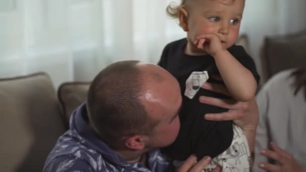 Οικογενειακές αξίες: μητέρα και πατέρας που παίζουν με το μωρό παιδί εσωτερικό-γονείς φορώντας μπλε και γκρι ρούχα σπίτι και ο γιος τους μαύρο και άσπρο-χαρούμενοι χαμογελαστοί άνθρωποι — Αρχείο Βίντεο