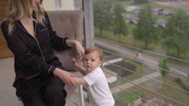 Balkonda oynamak - Genç sarışın anne aile evinde düz onun bebek erkek oğlu ile kaliteli zaman sahip - siyah budoir elbise kostüm uyku elbisesi giyiyor