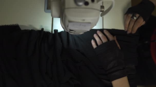 Κυβερνοπανκ σχεδιαστής μόδας στην εργασία στο στούντιό της ράψιμο χρησιμοποιώντας μηχανή-Καυκάσιος λευκή γυναίκα φορώντας κόκκινο μπλουζάκι και μαύρα γάντια με ψαλίδι κρέμεται πάνω από το στήθος της — Αρχείο Βίντεο