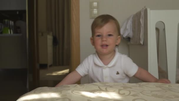 Retrato infantil de bebé niño caminando por el piso siendo curioso y feliz sonriendo usando polo corporal blanco - Objetivo de valores familiares - Madre e hijo caucásicos en casa — Vídeos de Stock