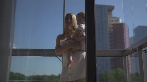 Beautiful young blonde mom playing with her baby boy son - Family values goal - Caucasian mother and child at home - Smooth cinematic handheld movement — Stock Video