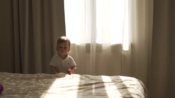 Retrato infantil de bebé niño caminando por el piso siendo curioso y feliz sonriendo usando polo corporal blanco - Objetivo de valores familiares - Madre e hijo caucásicos en casa — Vídeos de Stock