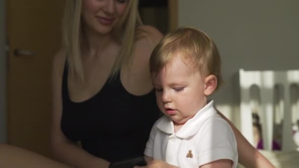 Mooie jonge blonde moeder spelen met haar baby jongen zoon-familie waarden doel-Kaukasische moeder en kind thuis-Smooth cinematische handheld beweging — Stockvideo