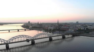Riga şehrinin havadan çekilmiş görüntüsü - Letonya'da Avrupa başkenti - Drone top view sinematik profesyonel panning - Eski şehir ve demiryolu köprüsü