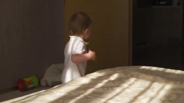 Beyaz vücut polo giyen meraklı ve mutlu gülümseyerek düz etrafında yürüyüş erkek bebek çocuk portre - Aile değerleri hedef - Evde Kafkas anne ve çocuk