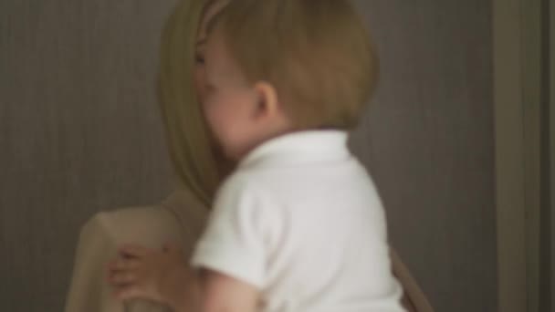 Hermosa mamá rubia joven jugando con su hijo bebé - Objetivo de valores familiares - Madre e hijo caucásicos en casa - Movimiento de mano cinematográfico suave — Vídeo de stock