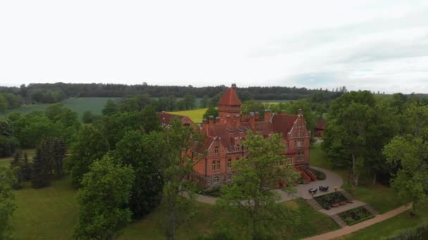 Εναέρια πετούν πάνω από το παλιό αρχοντικό του κάστρου στη Λετονία-ο Ικούμοκου Pils από πάνω από την κορυφή θέα κατά τη διάρκεια του καλοκαιριού και πράσινα δέντρα γύρω — Αρχείο Βίντεο