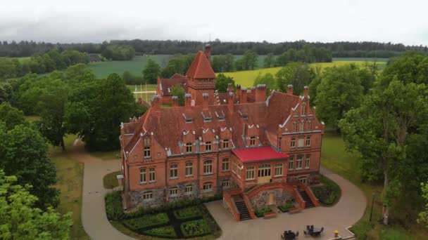 Lucht vliegen over oude kasteel Manor in Letland-Jaunmoku pils van bovenaf top uitzicht tijdens de zomer en groene bomen rond — Stockvideo