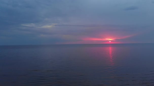 空中惊人的黑暗风景生动的深红色罕见的红色日落与紫色和洋红色的颜色在波罗的海与小太阳在地平线 - 无人机飞行视图从上面 — 图库视频影像