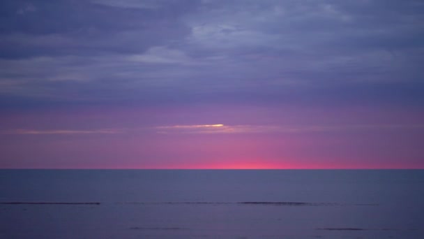 地平線に小さな太陽とバルト海で紫とマゼンタの色と驚くほど暗い風光明媚な鮮やかな真紅の赤い夕日 — ストック動画