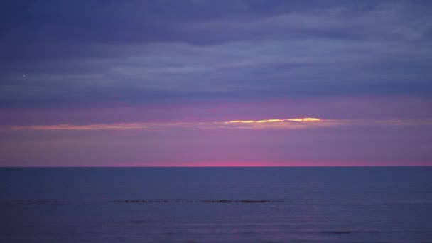 Increíble oscuro paisaje vívido carmesí rara puesta de sol roja con colores violeta y magenta en el Mar Báltico con pequeño sol en el horizonte — Vídeo de stock