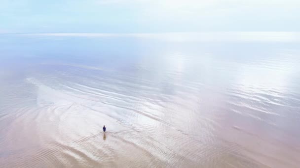 Luchtfoto: jonge vrouw in blauwe heldere jurk rond te lopen-ondiep water Scenic geelachtige zonsondergang landschap aan de Baltische Zee-drone Flying View van bovenaf — Stockvideo