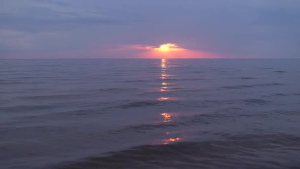 地平線に小さな太陽とバルト海で紫とマゼンタの色と驚くほど暗い風光明媚な鮮やかな真紅の赤い夕日 — ストック動画