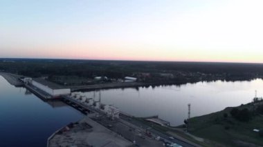 Akşam gün batımında Riga Daugava Nehri üzerinde hidroelektrik güç istasyonu üzerinde Uçan Hava