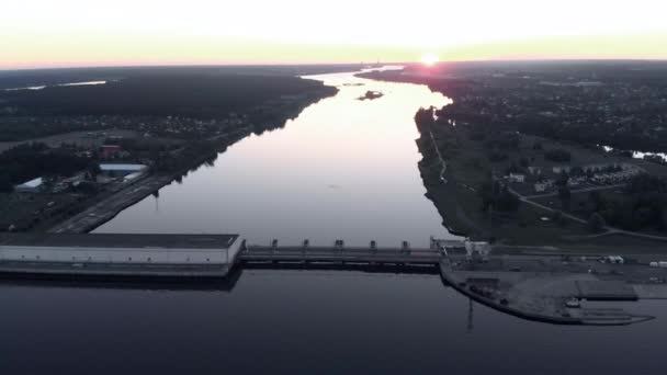 Εναέρια πτήση πάνω από τον υδροηλεκτρικό σταθμό στον ποταμό κόρη στη Ρίγα το βράδυ του ηλιοβασιλέματος — Αρχείο Βίντεο