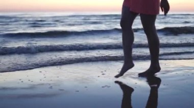 Parlak ihale kırmızı elbiseli genç kadın Sunset de yaşam ve doğa uzak arka plan zevk plaj boyunca yürüyüş