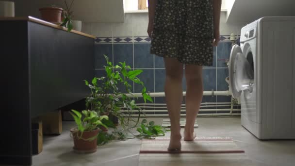 Triste y Fallar: Mujer con piernas desnudas pesándose en escamas - Chica blanca caucásica con un vestido de verano punteado en un baño — Vídeos de Stock