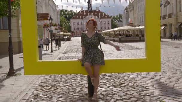 Femme rousse touristique dans une belle ville européenne Tartu, Estonie fille blanche caucasienne portant une robe d'été pointillée — Video