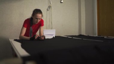 Siber punk moda tasarımcısı onu stüdyo kesim desen iş başında - Beyaz beyaz kadın göğsünde asılı makas ile kırmızı t-shirt ve siyah eldiven giyiyor