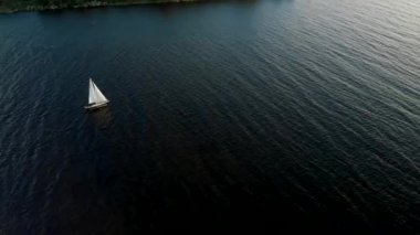 Hava: Güzel 4k küçük bir yat tekne su taşıma aşağıdaki - Yukarıdan Daugava nehir rüzgarlı rüzgarlı hava bir kuş bakışı görünümü - Sunset drone üst görünümü
