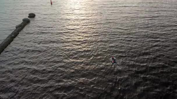 Antenn: vacker 4K efter en liten båt vatten transport-en fågelperspektiv över Daugava floden blåsigt blåsig väder från ovan-Drone ovanifrån vid solnedgången — Stockvideo