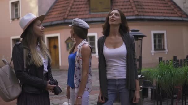 Three traveling girl friends with light backpacks walking exploring Riga city - Travel tourism concept after transfer from airport - Wearing hats and jeans — Stock Video